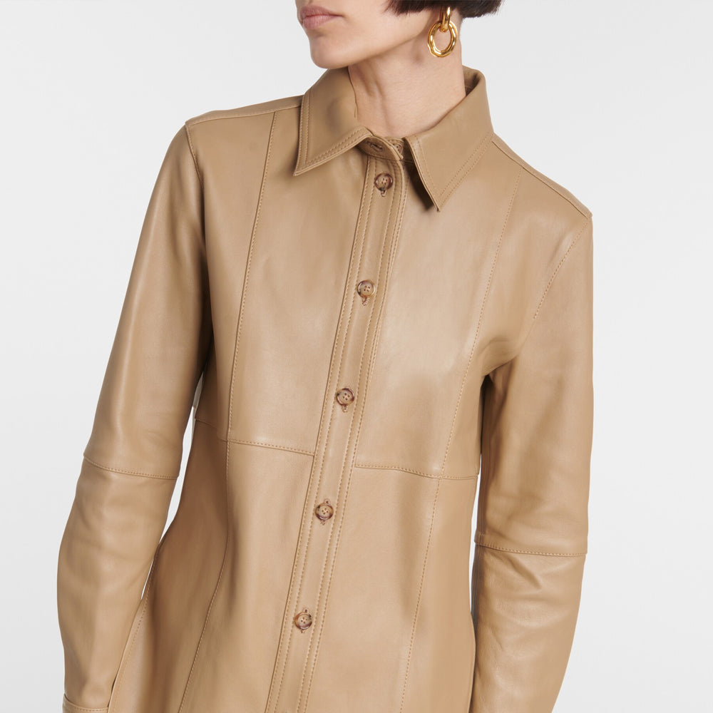 Tan leather jacket worn by a person on a white background