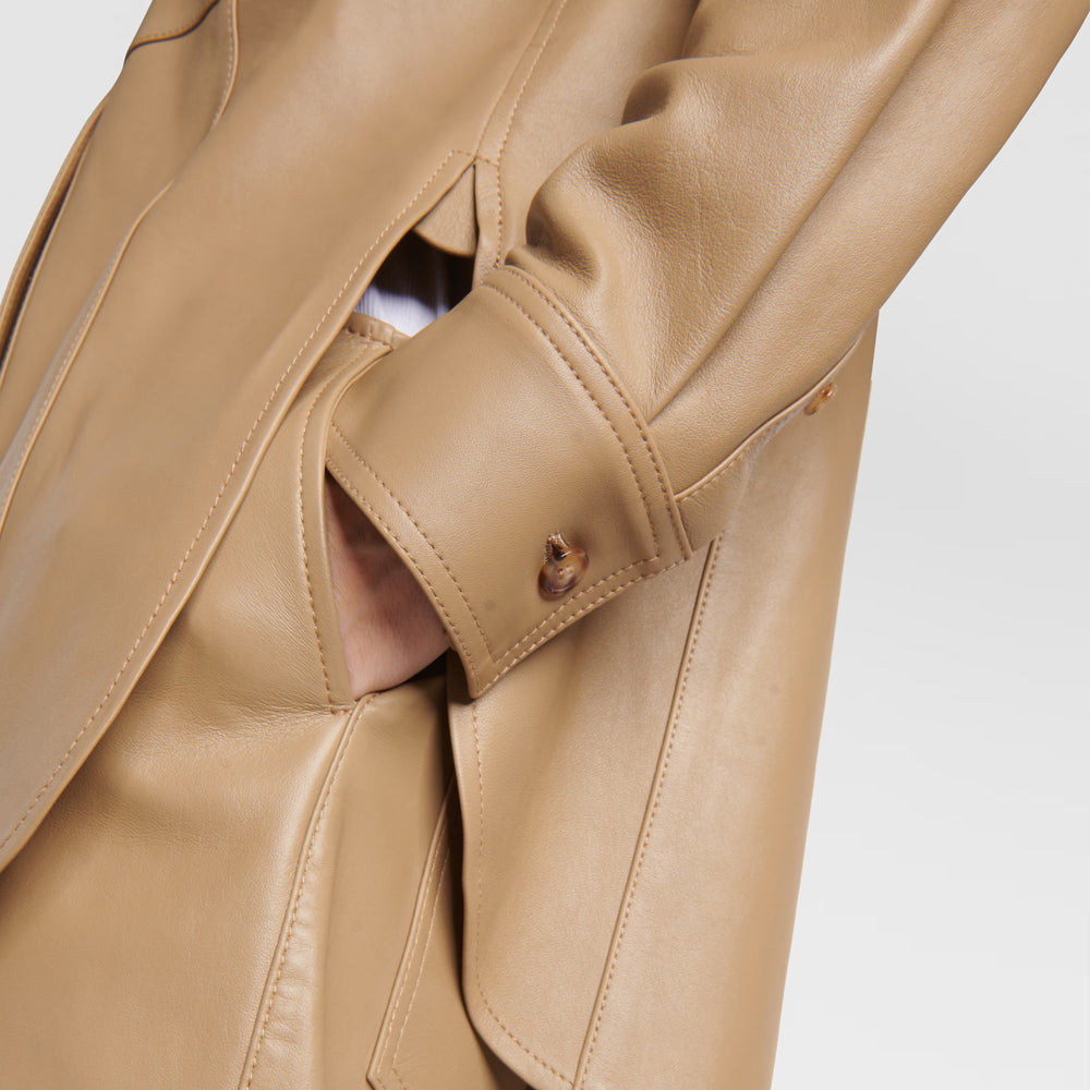 Close-up of a beige leather jacket on a light gray background