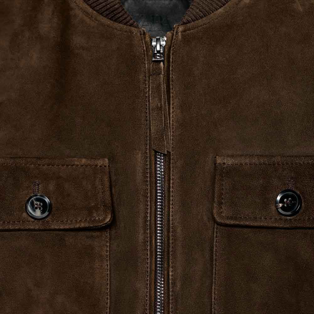 Close-up of a brown suede jacket with zippers and buttons.