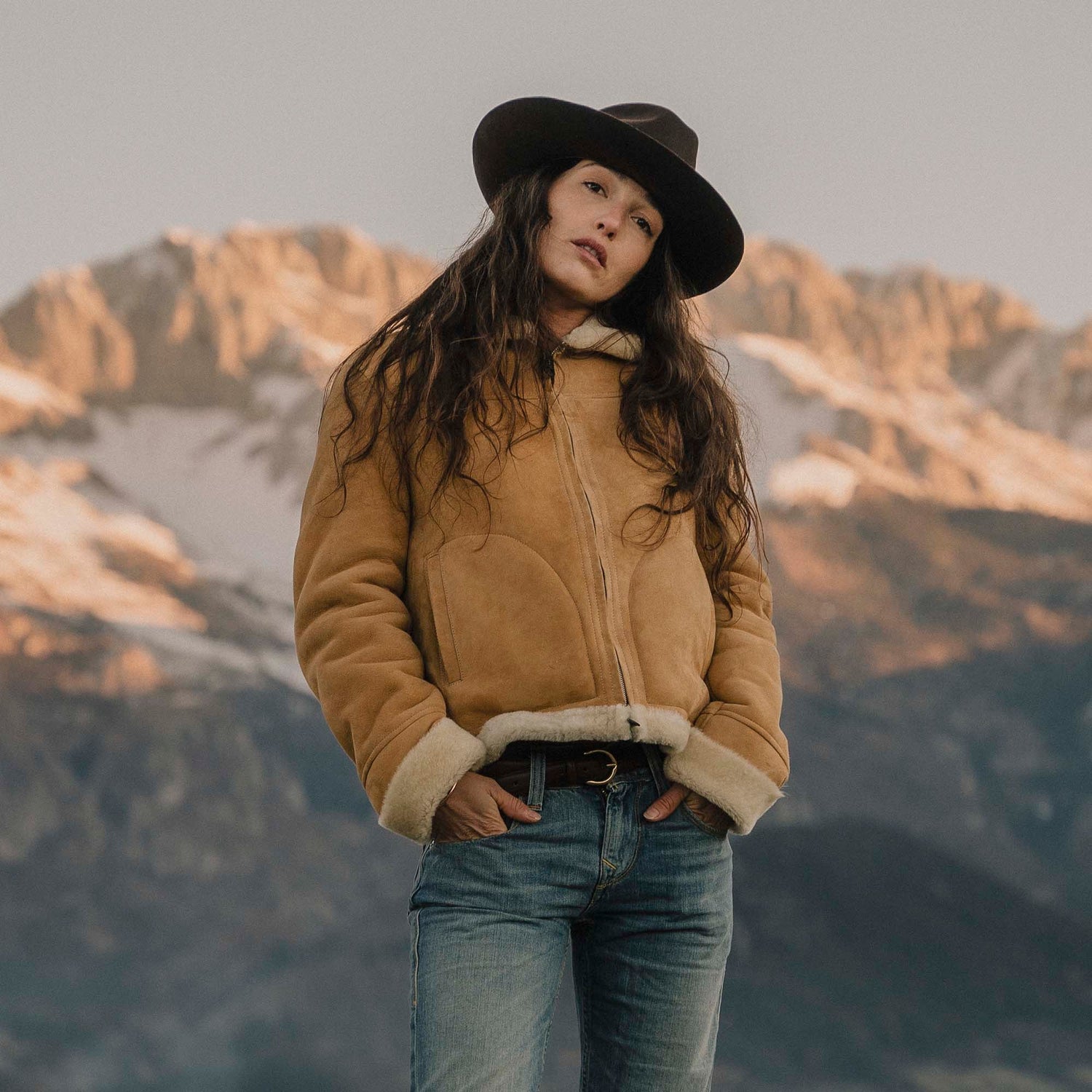 women wearing brown shearling jacket and cowboy hat