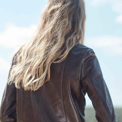 Person wearing a brown leather jacket with a blurred background