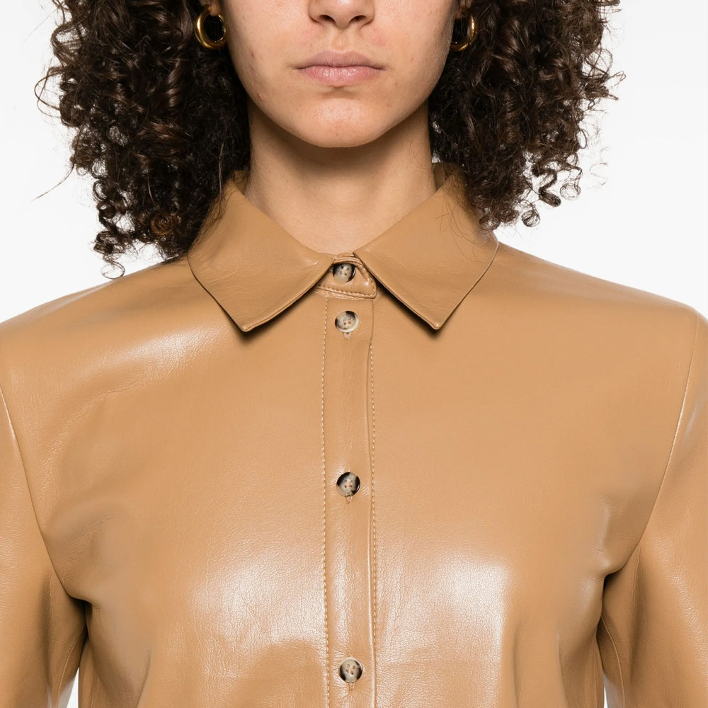 Close-up of a person wearing a beige leather jacket on a white background