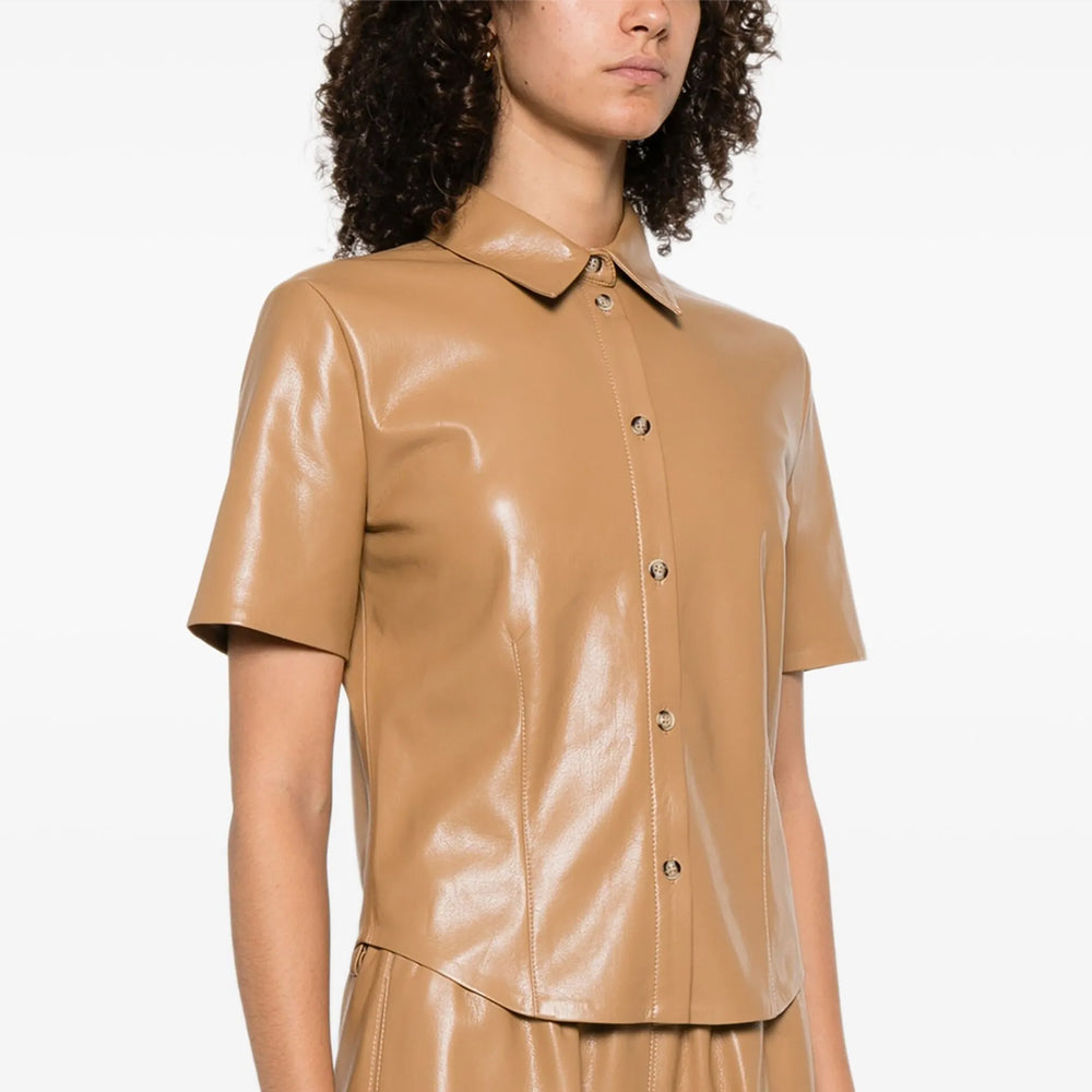 Person wearing a beige shiny shirt on a white background
