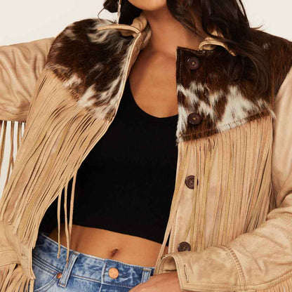 Person wearing a beige fringed jacket with cowhide pattern and black top
