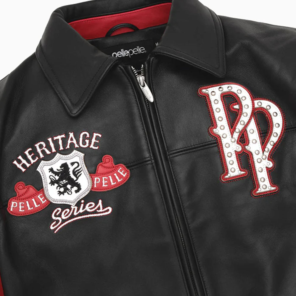 Close-up of a black leather jacket with a collar, front zipper, and embroidered details. The left chest reads 'HERITAGE PELLE Series' with a shield crest, and the right chest features a large 'PP' monogram with studs.