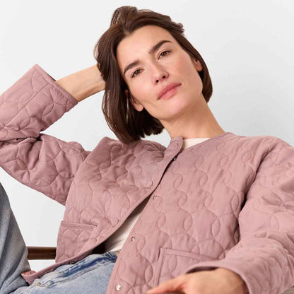 close up of a woman wearing pink quilted pattern jacket