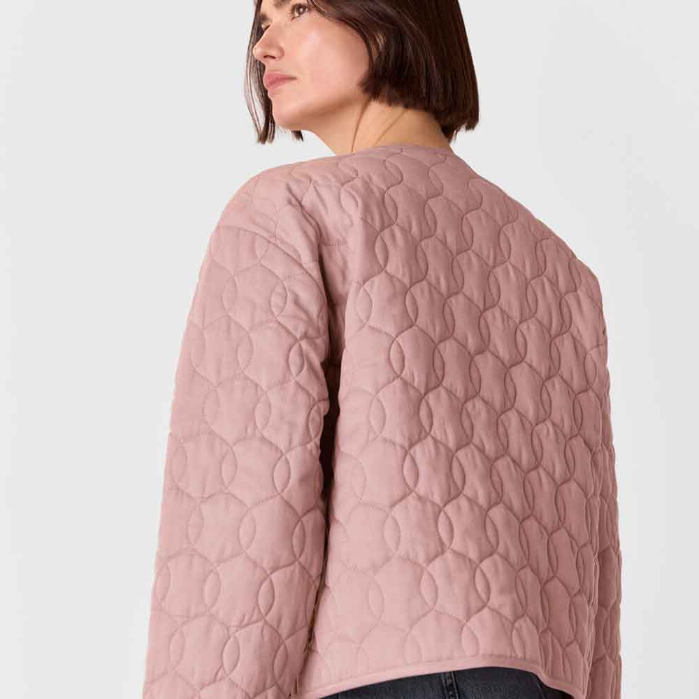 a women wearing pink quilted jacket 