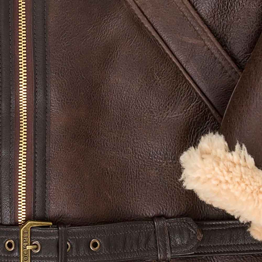 Close-up of a brown leather jacket with fur lining and gold zipper.