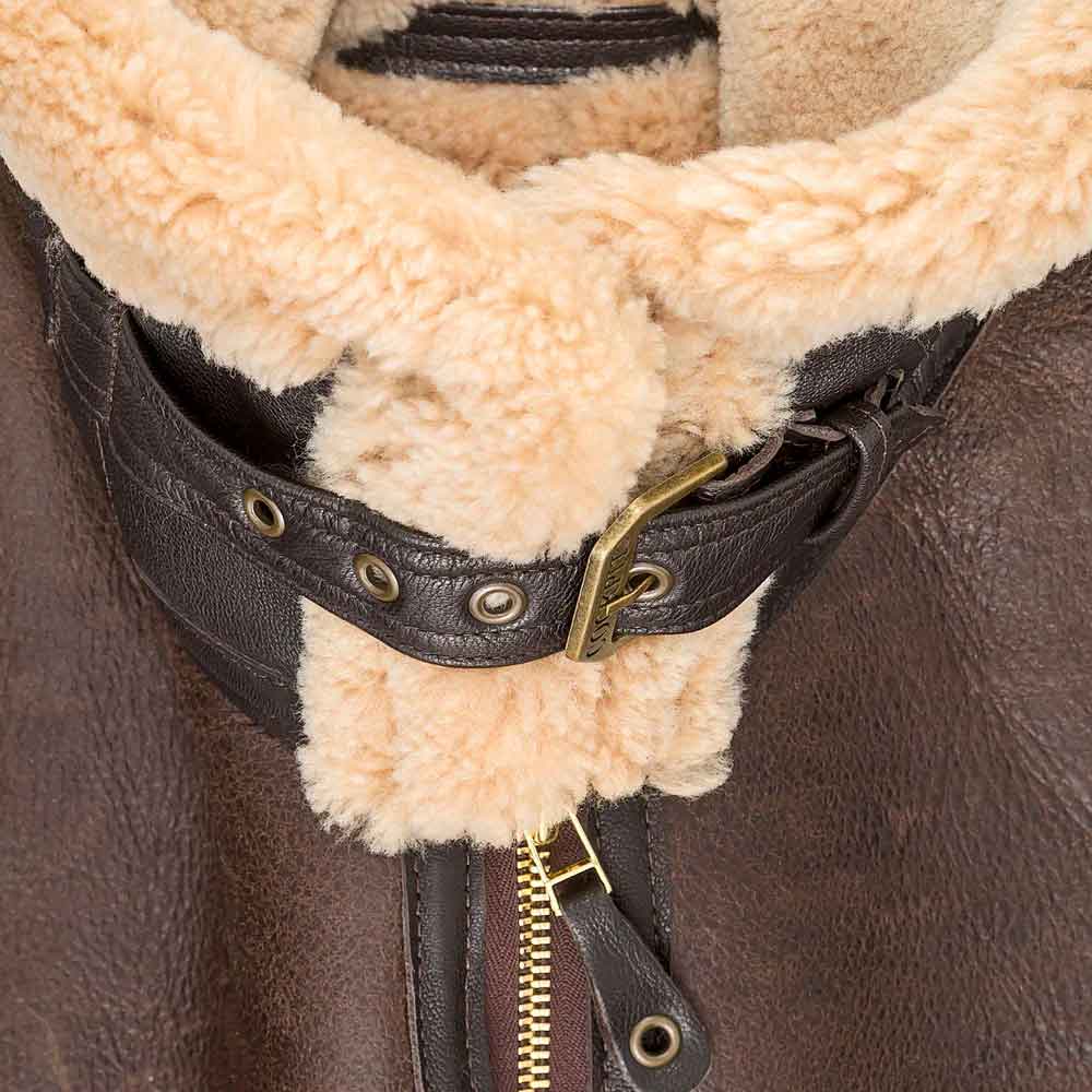 Close-up of a brown leather jacket with beige fleece lining and gold zipper.