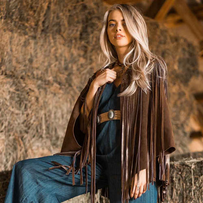 Woman wearing a brown fringed leather jacket in a rustic setting