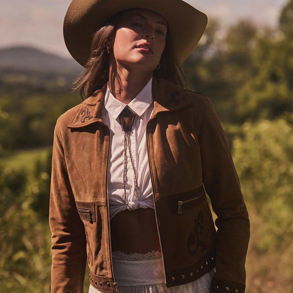 Person wearing a brown jacket and hat in a natural setting
