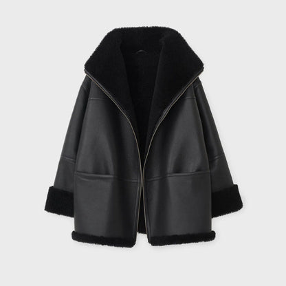 Black leather jacket with fur trim on a light gray background