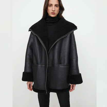 Woman wearing a black leather coat with a white background