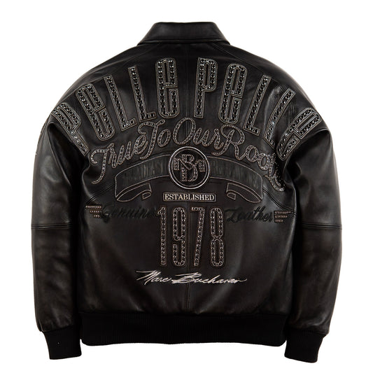 Black leather jacket shown from the back, featuring a large decorative graphic with the words 'pelle Pelle', 'Due To Our Roots', 'Established 1978', and 'New Bachelors' embellished with rhinestone-like detailing, on a white background.