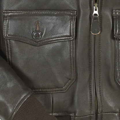 Close-up of a dark leather jacket with a pocket and zipper.