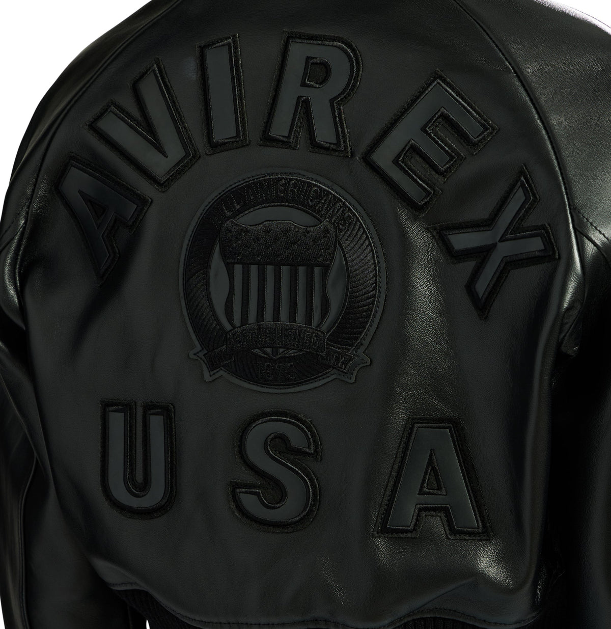 Close-up of black AVIREX and USA leather back lettering