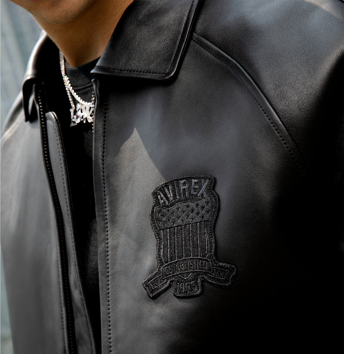 Tonal USA lettering on the back of black Avirex leather jacket