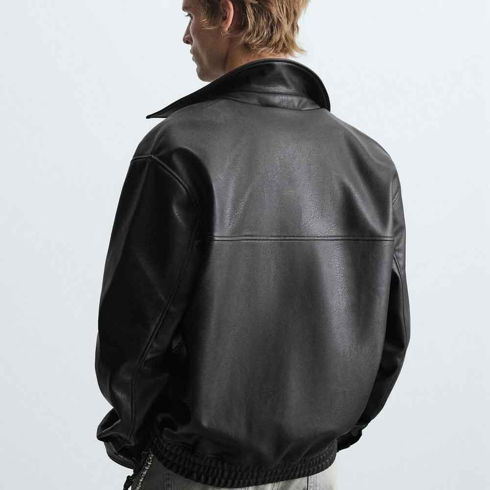 Person wearing a black leather jacket on a plain background