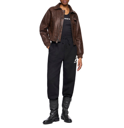 Woman wearing a brown cropped Avirex croc-effect leather jacket